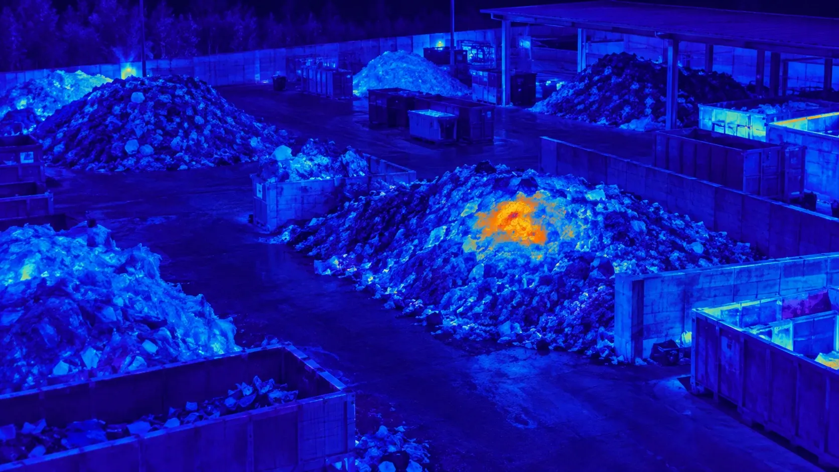 Immagine termica notturna di un centro di raccolta con un punto caldo sulla superficie di un cumulo